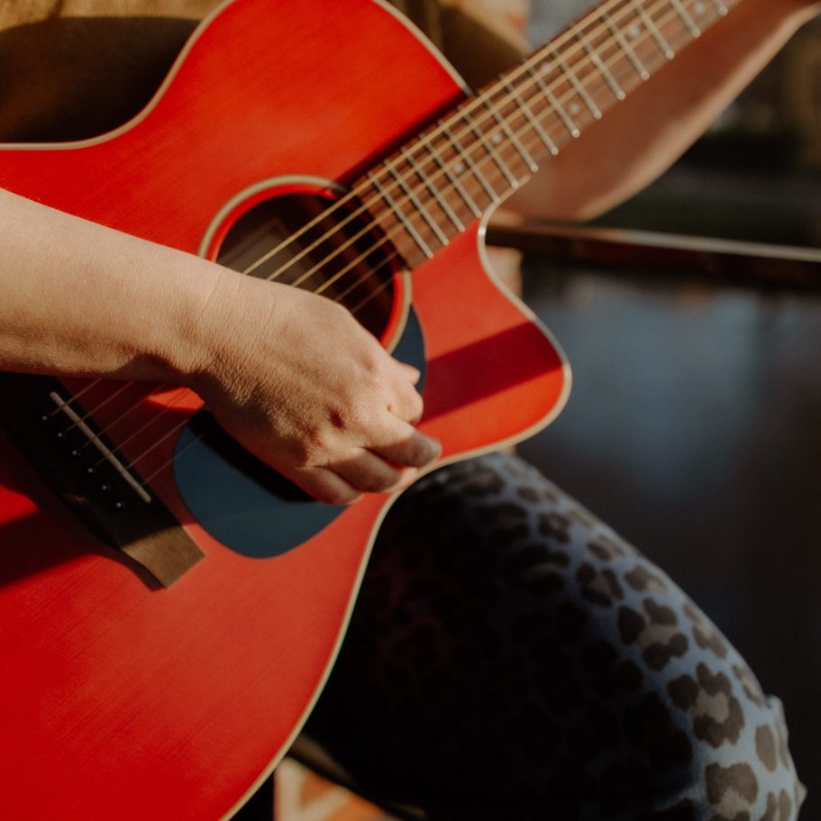 Detailansicht von Gitarre und Hand, die Gitarre spielt